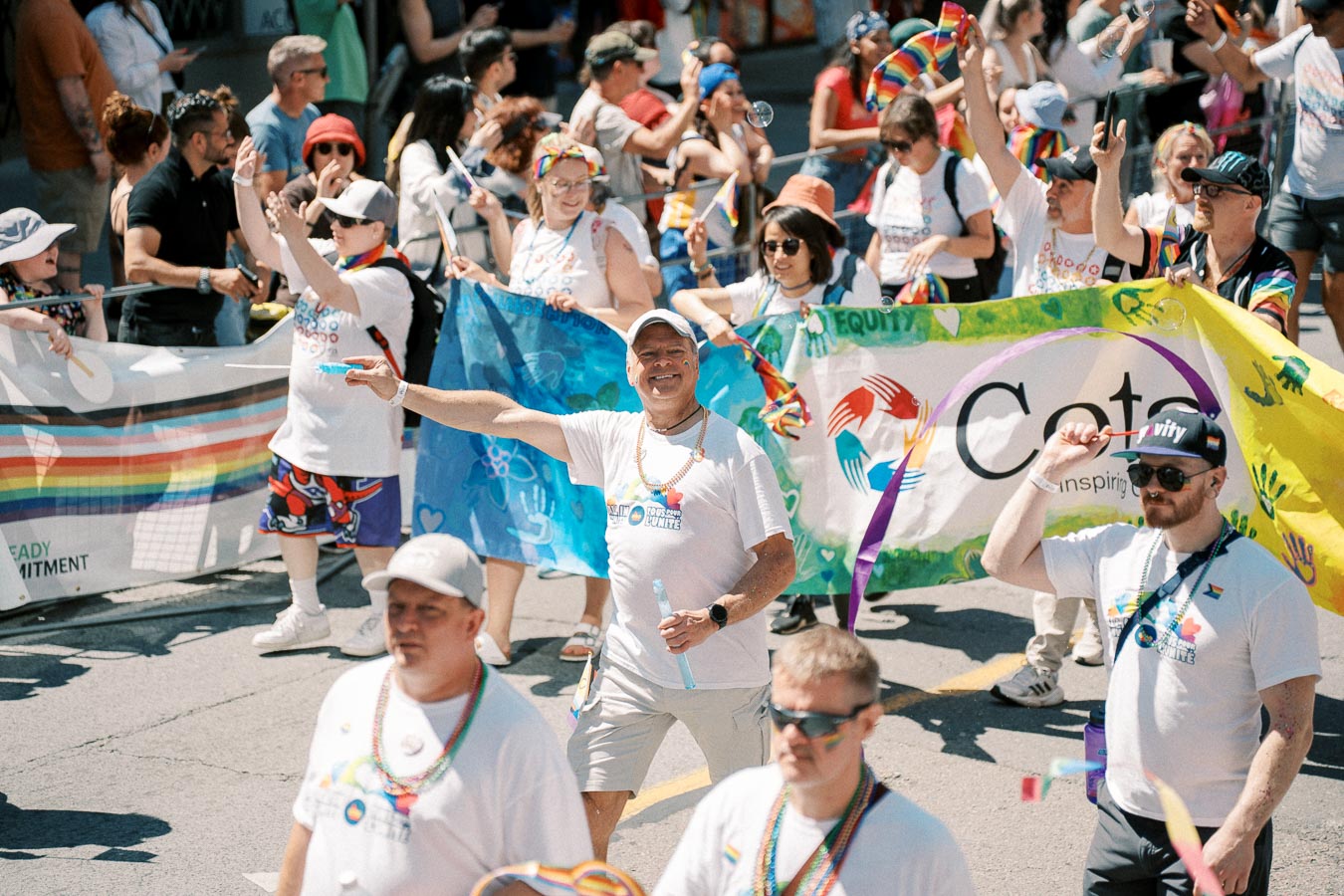 Participants in a pride parade celebrate with colorful banners and rainbow-themed accessories, promoting inclusivity and diversity.