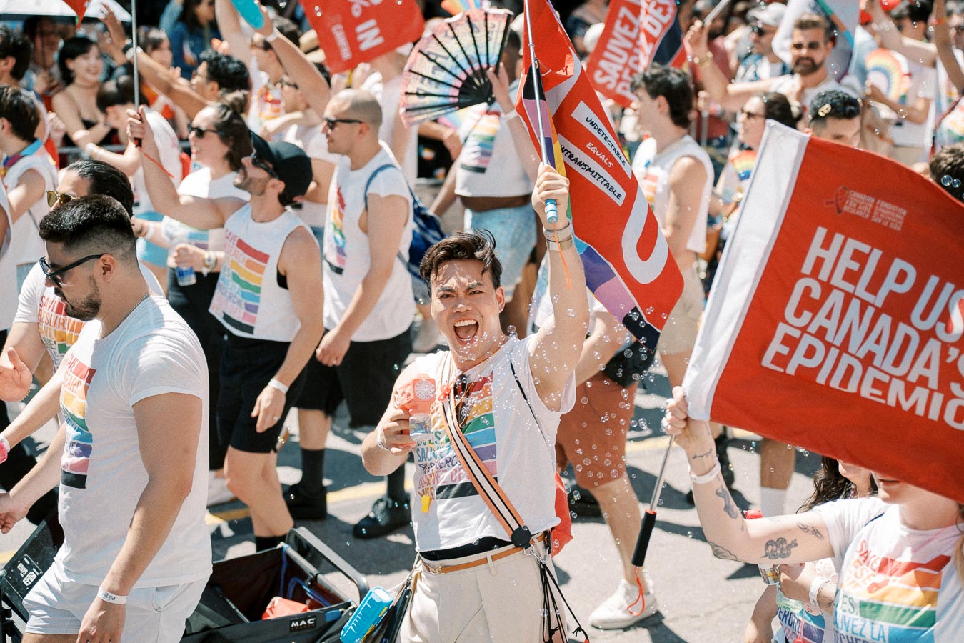 Participants in a pride parade celebrate with rainbow-themed attire and flags, promoting awareness and inclusivity.