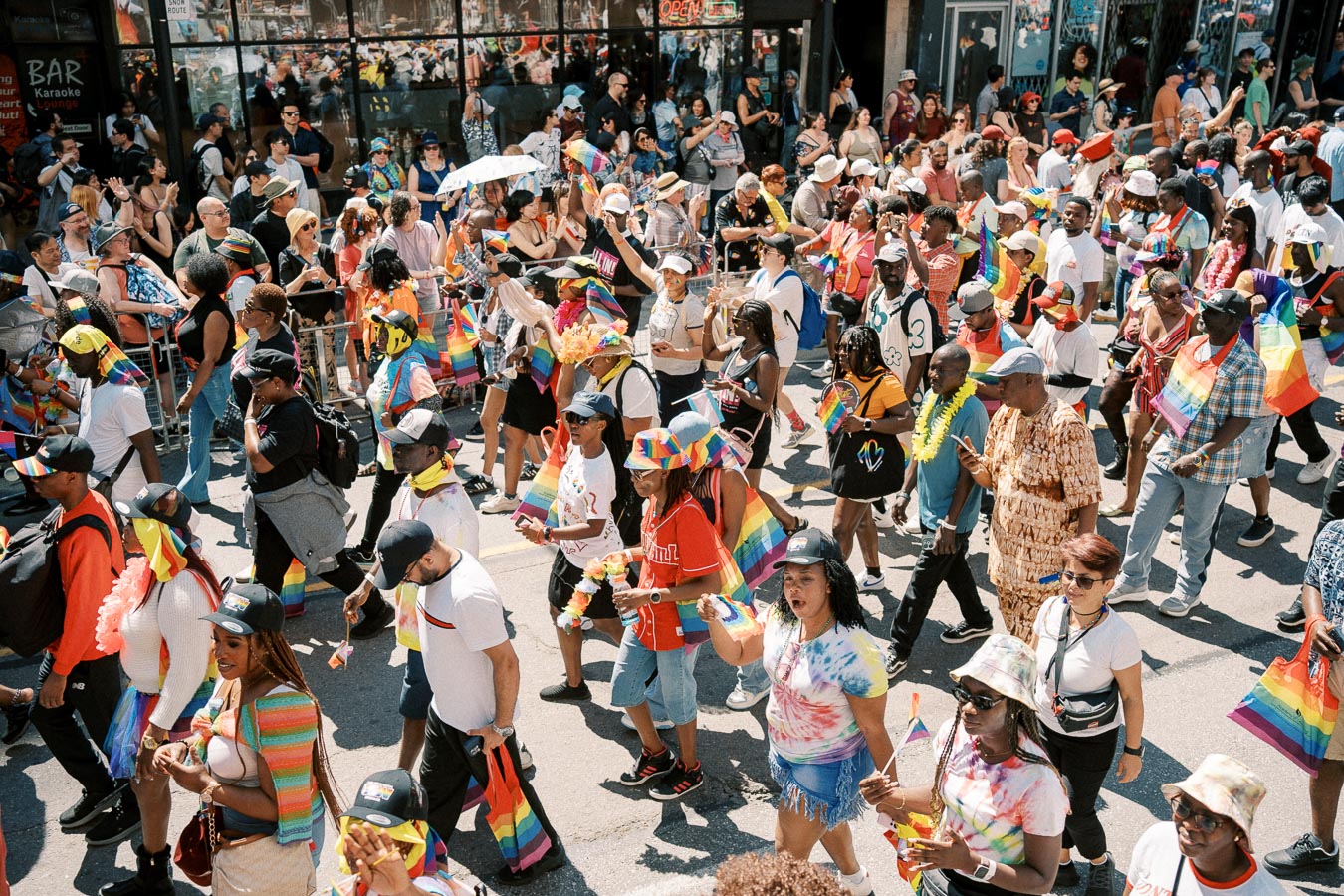 A vibrant pride parade with participants celebrating diversity and inclusion, adorned with rainbow flags and colorful attire.