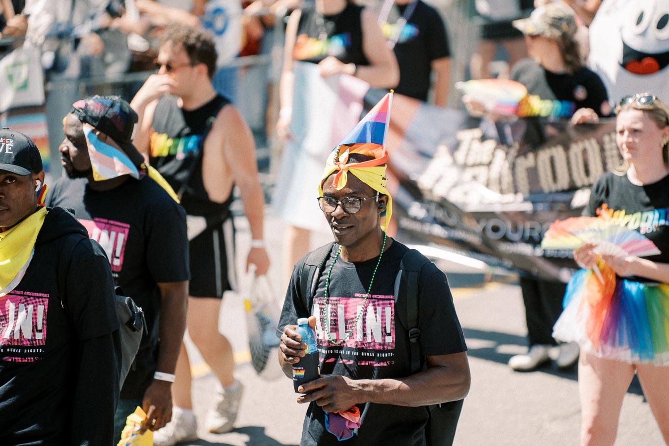 Participants at a pride parade wearing colorful attire and accessories, celebrating diversity and inclusion.