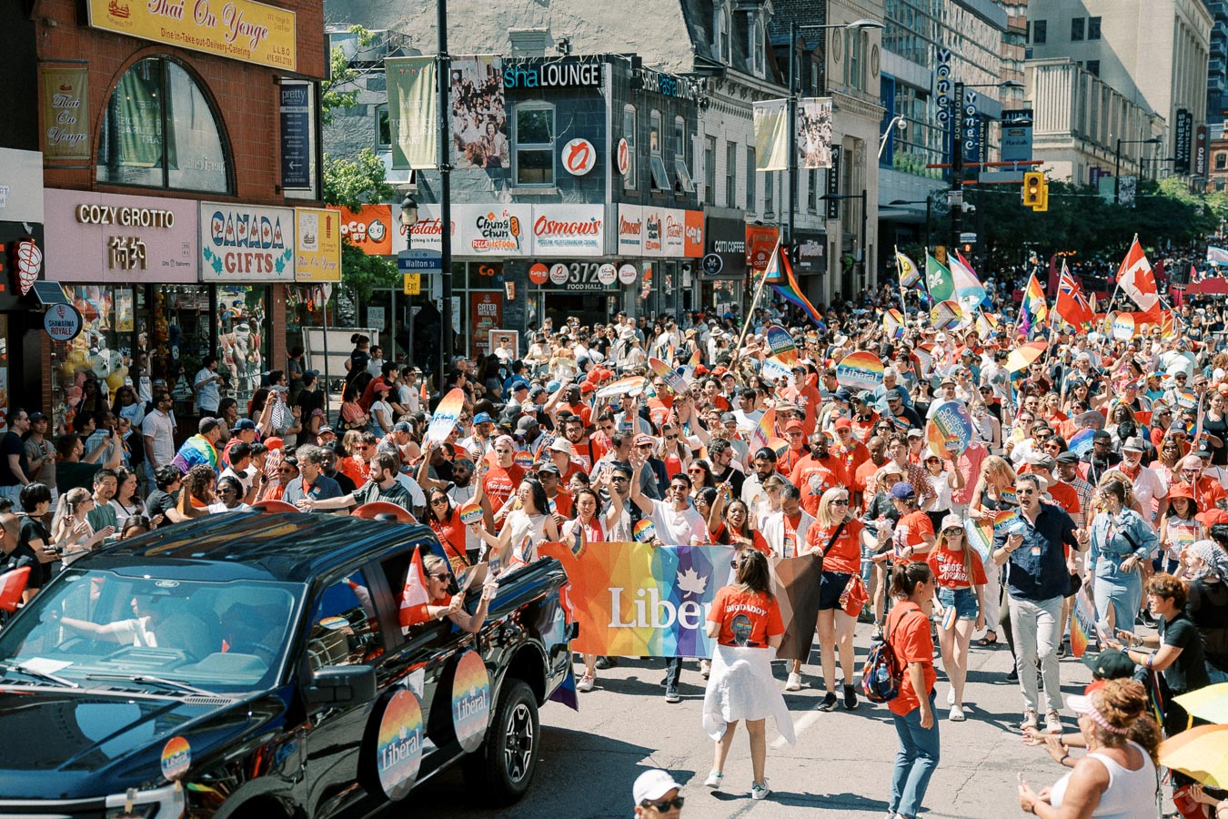 A vibrant pride parade takes place on a bustling city street, with participants waving rainbow flags and banners, celebrating diversity and inclusion.