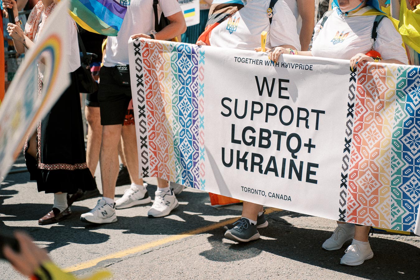 Participants at a parade in Toronto hold a banner supporting LGBTQ+ rights in Ukraine.