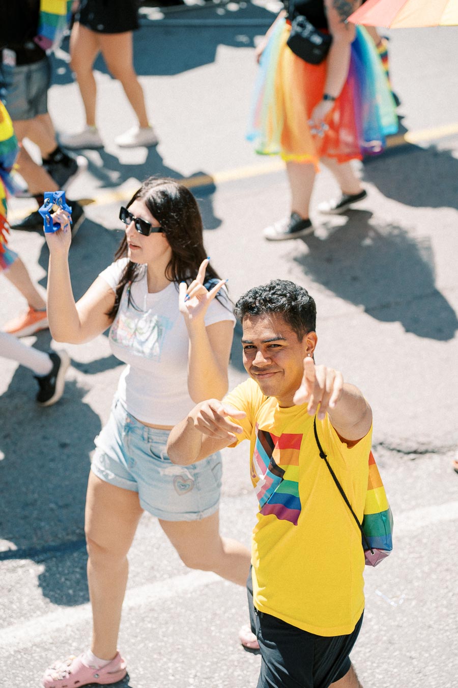 Participants at a pride parade wearing colorful outfits and rainbow-themed accessories, celebrating diversity and inclusion.