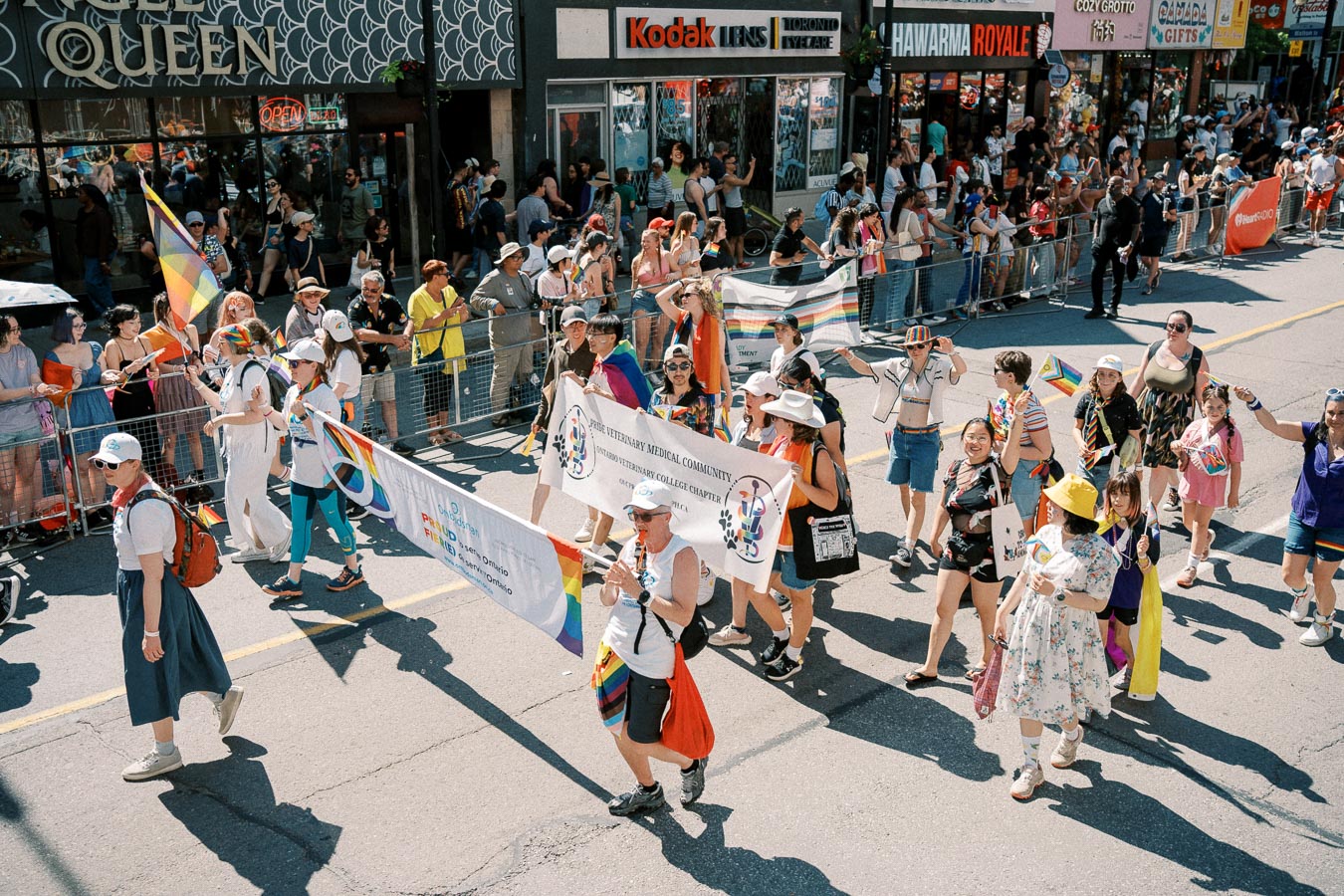 Participants march in a pride parade, celebrating diversity and inclusion with banners and rainbow flags.
