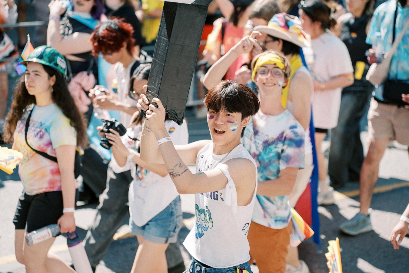 Participants in a vibrant pride parade, showcasing colorful attire and joyful expressions.