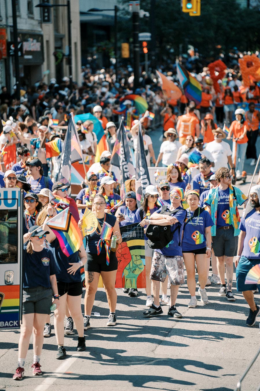 Participants in a pride parade march with rainbow flags and banners, celebrating diversity and inclusion.