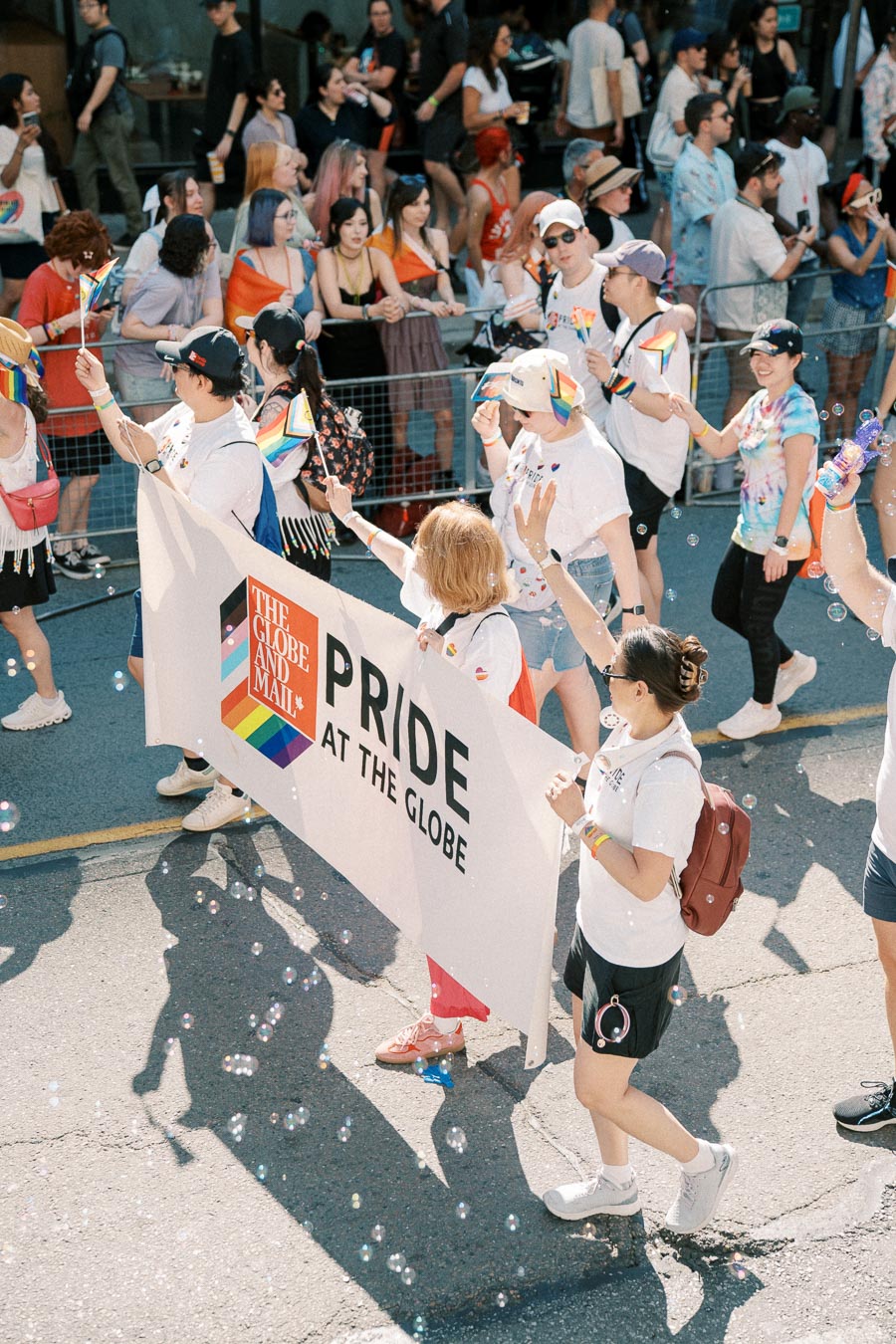 Participants in a Pride parade hold a banner reading 'Pride at the Globe', celebrating diversity and inclusion.