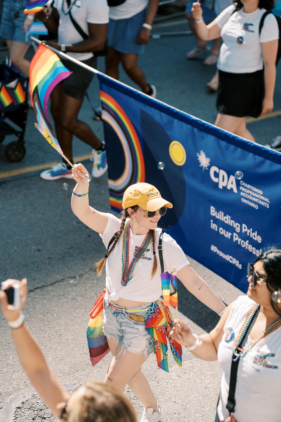 Participants in a pride parade celebrate with rainbow flags and colorful attire, promoting inclusivity and diversity.