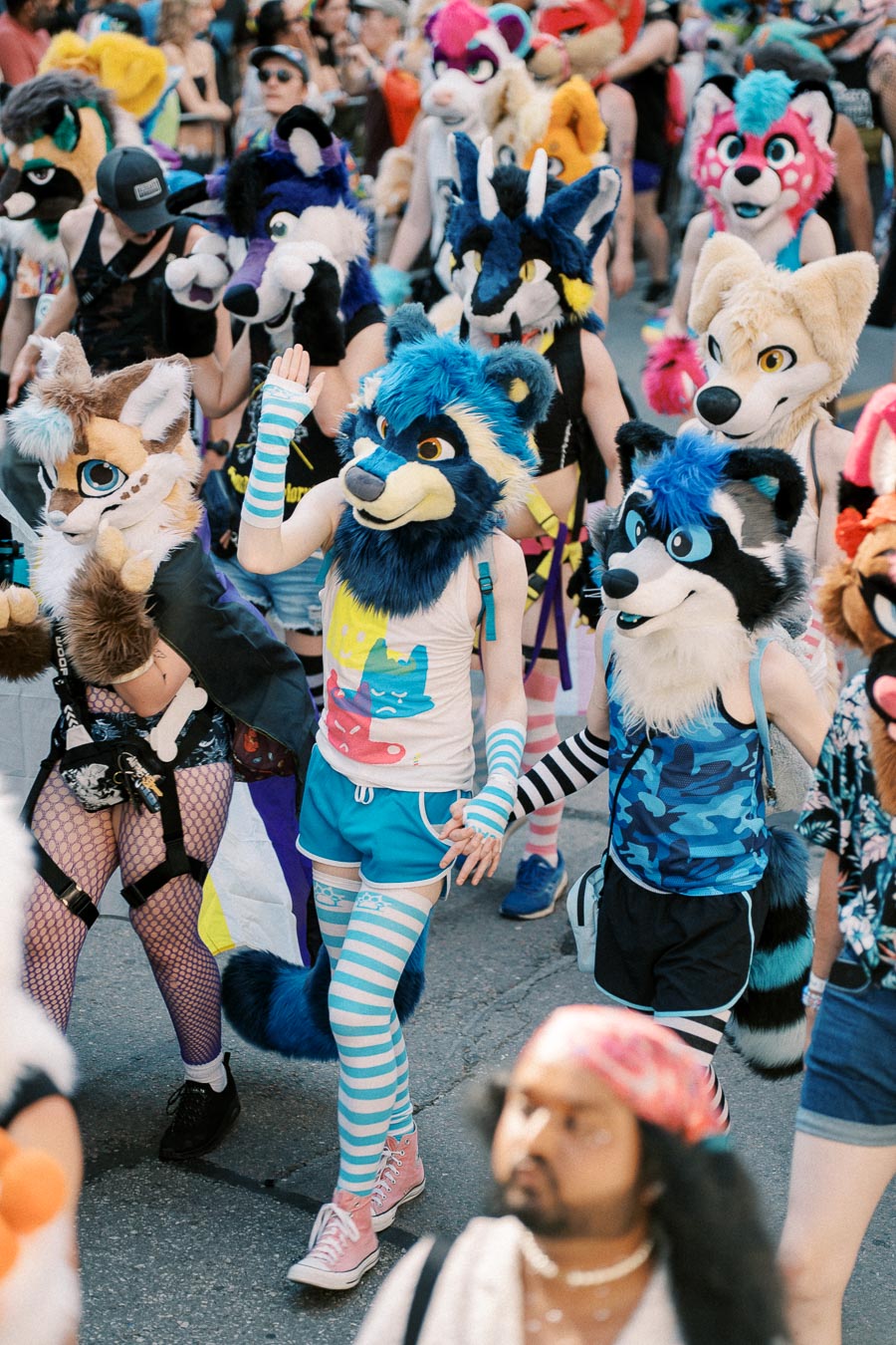 A vibrant gathering of people dressed in colorful animal costumes, likely participating in a parade or festival.