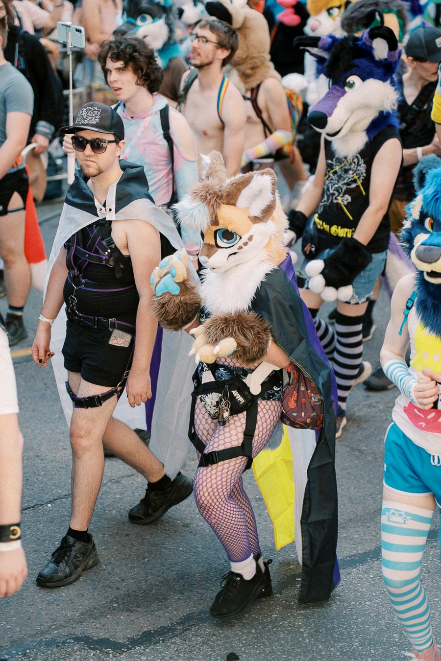 Participants in colorful costumes and fursuits take part in a lively parade, showcasing creativity and diversity.