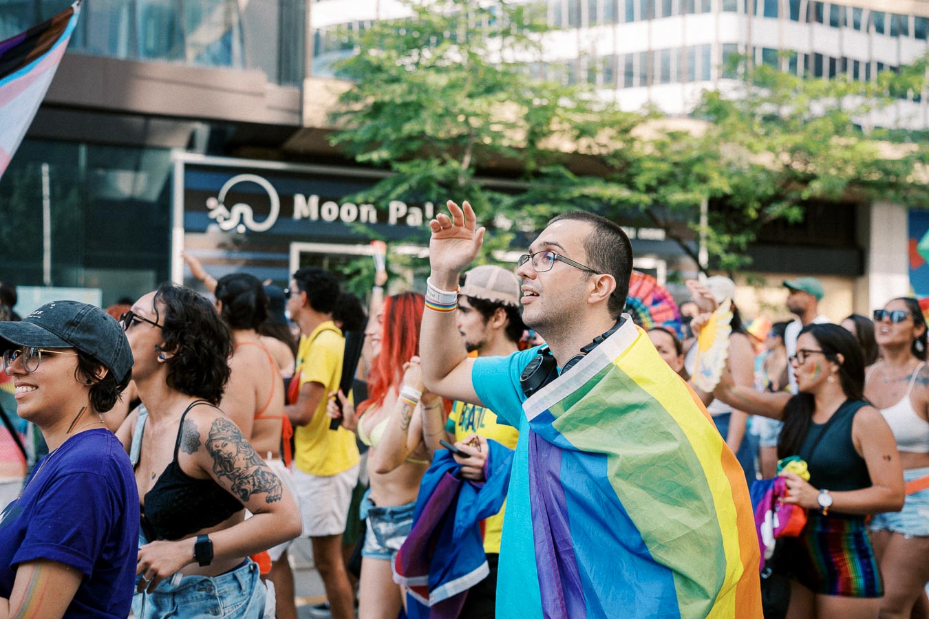 Participants celebrate at a pride parade, showcasing vibrant colors and joyful expressions.