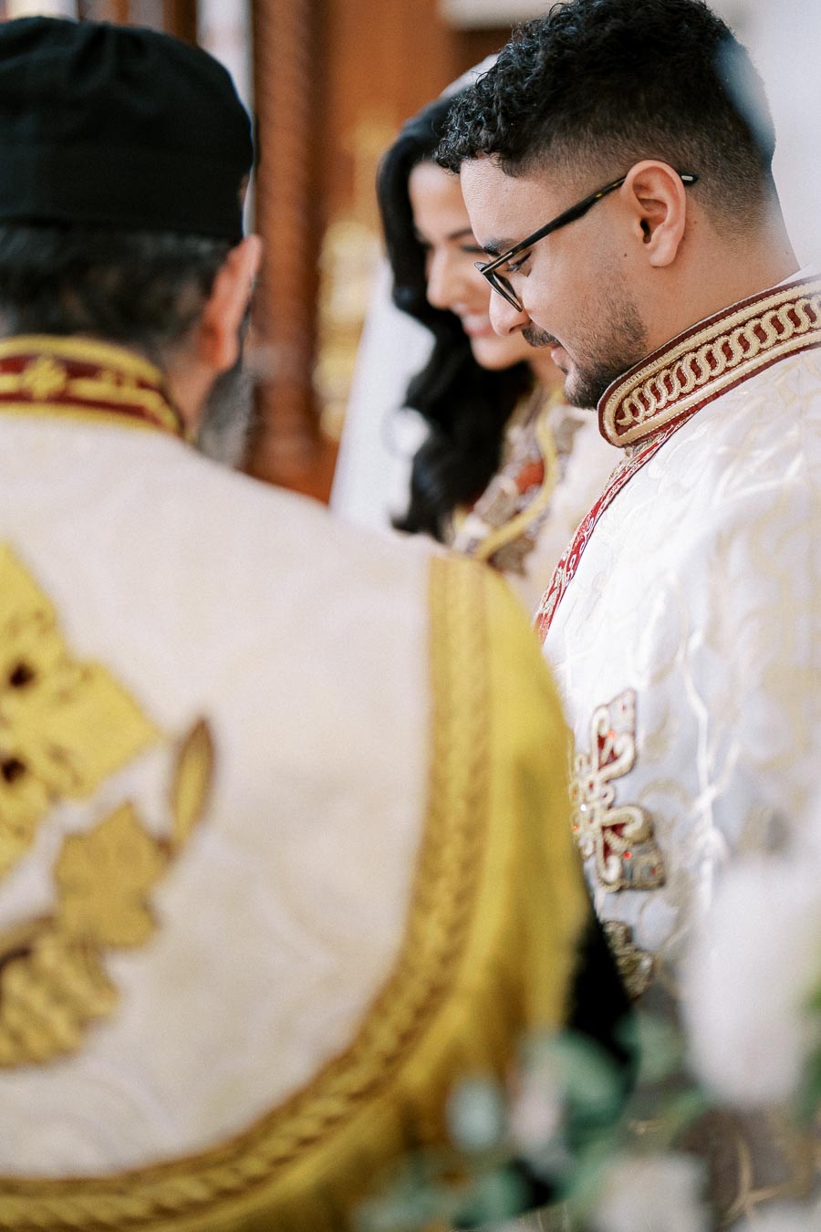 Religious wedding ceremony with a priest and couple dressed in ornate, traditional garments.