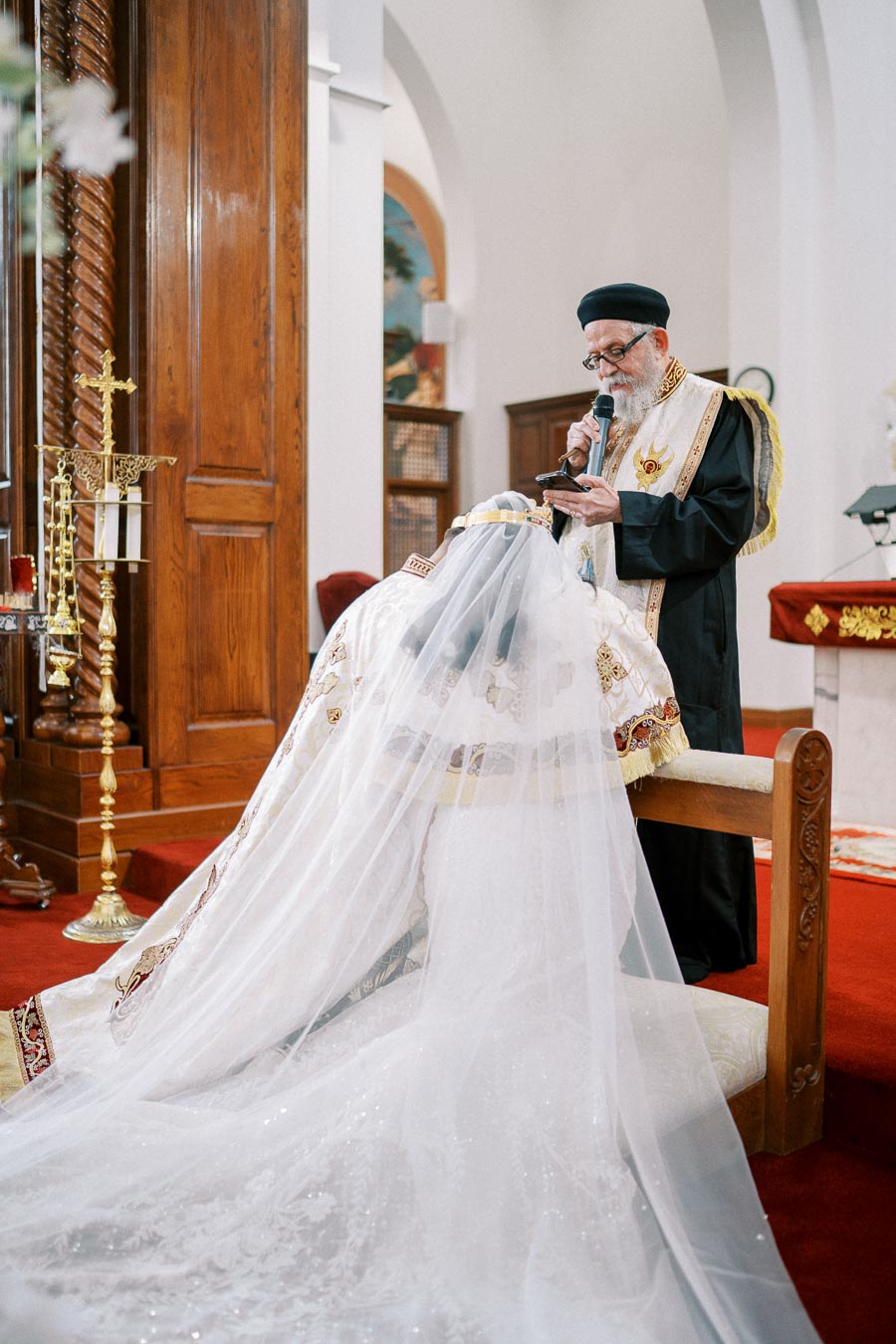 Clergyman in ecclesiastical garments conducting a traditional religious ceremony in a church.