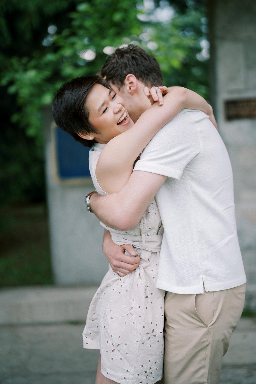 A cheerful couple embracing in a park, showcasing happiness and affection amidst a green, natural background.