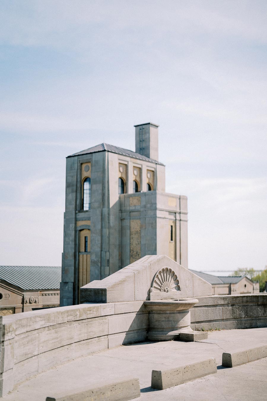 Historic architectural building with stone facade under a clear blue sky. Features ornate detailing and arched windows, capturing a serene, timeless atmosphere.