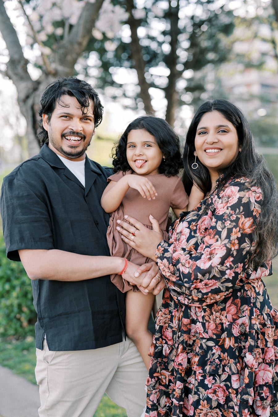 A happy family enjoying a day outdoors, posing together with smiles and laughter.