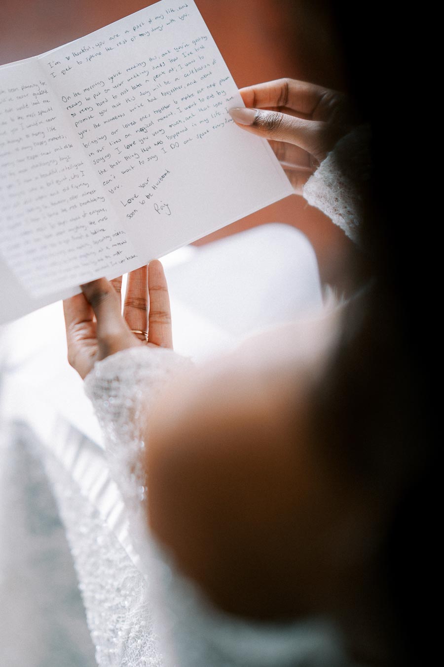 A woman in a sparkly sweater holding and reading a heartfelt handwritten letter, capturing an intimate and emotional moment.