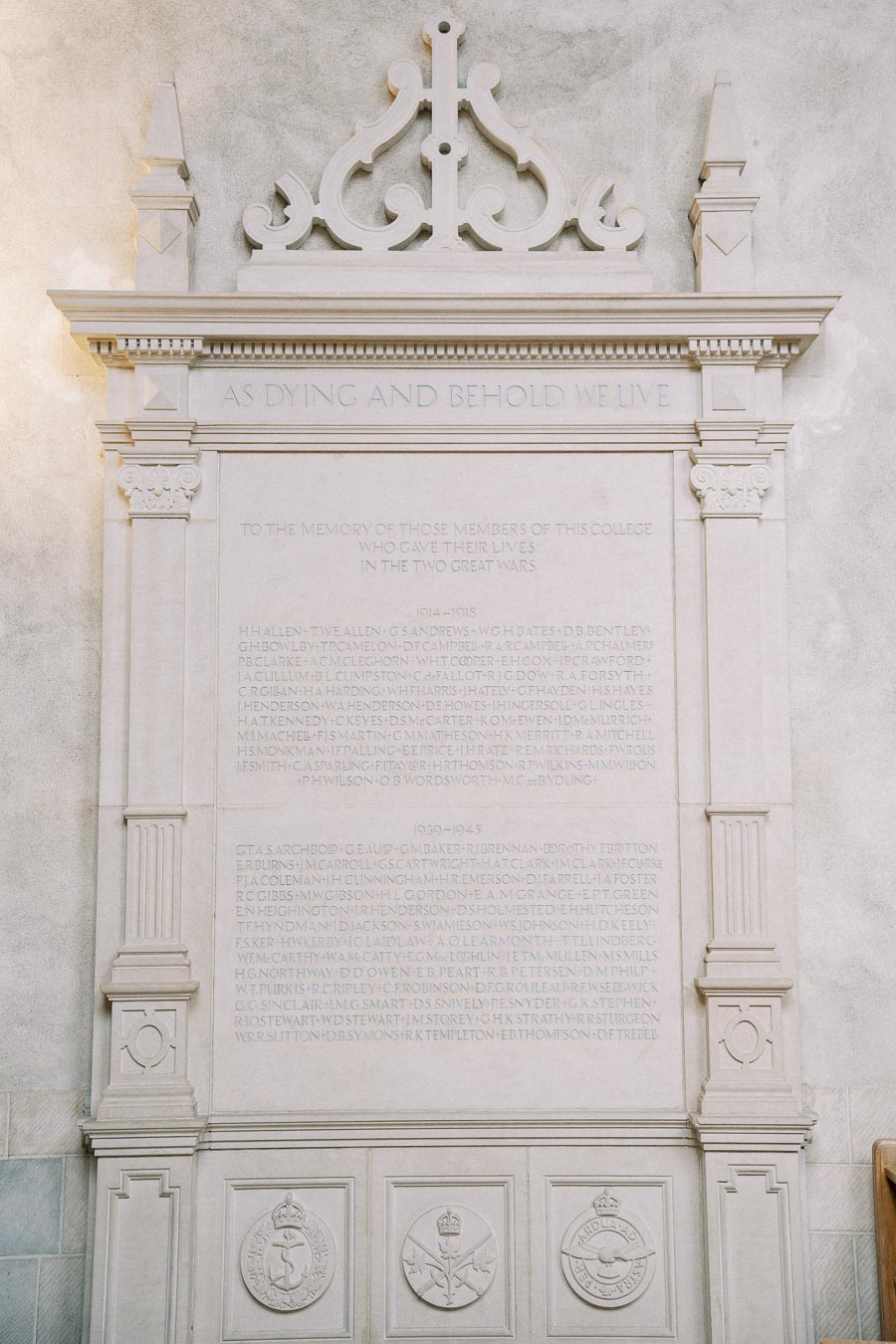 Wall-mounted memorial plaque honoring college members who died in the two World Wars, with engraved names, decorative carvings, and commemorative inscriptions.