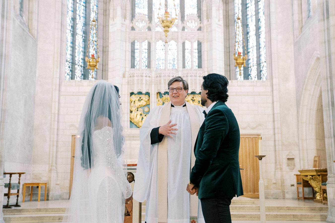 Couple standing at the altar with officiant in a beautiful church wedding ceremony