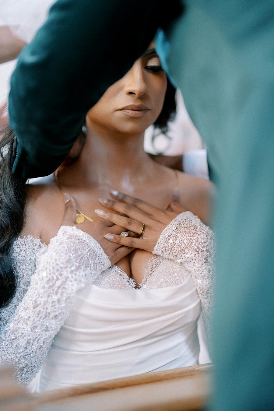 Elegant bride in a lace wedding dress with delicate jewelry, preparing for her big day.