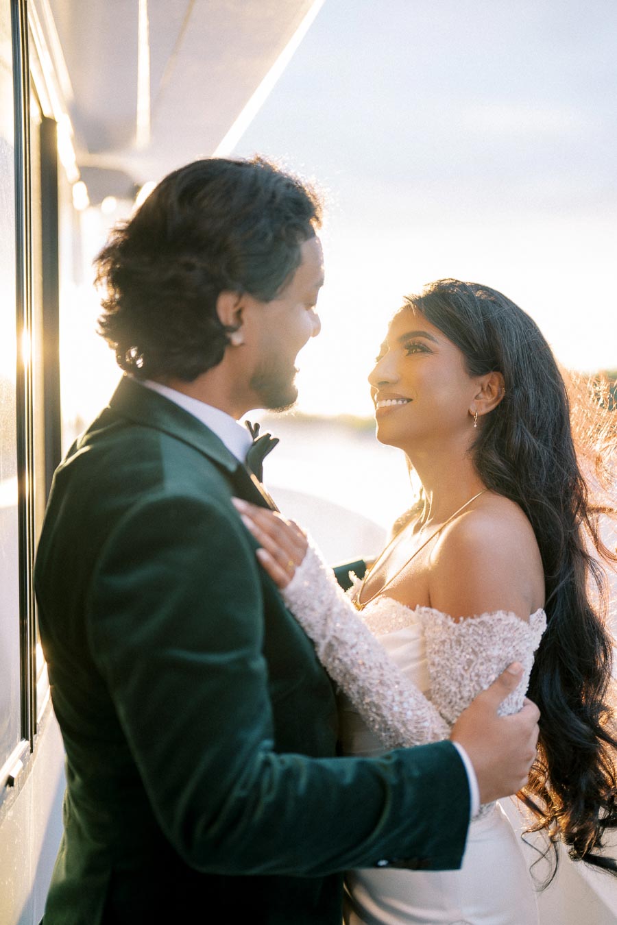 Romantic couple embraces on a sunlit balcony during golden hour, showcasing a special moment of love and happiness.