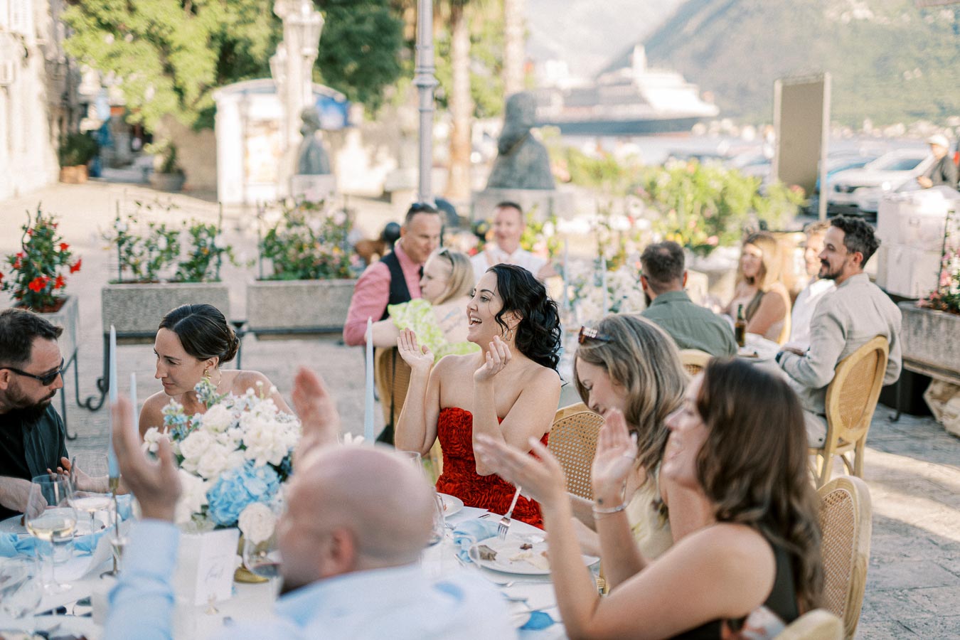 Guests enjoying an outdoor wedding reception, with elegantly set tables and scenic views of the waterfront in the background.
