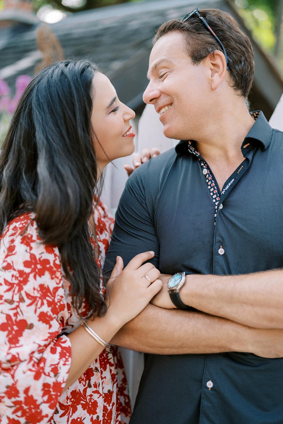Happy couple smiling at each other in a romantic outdoor setting.