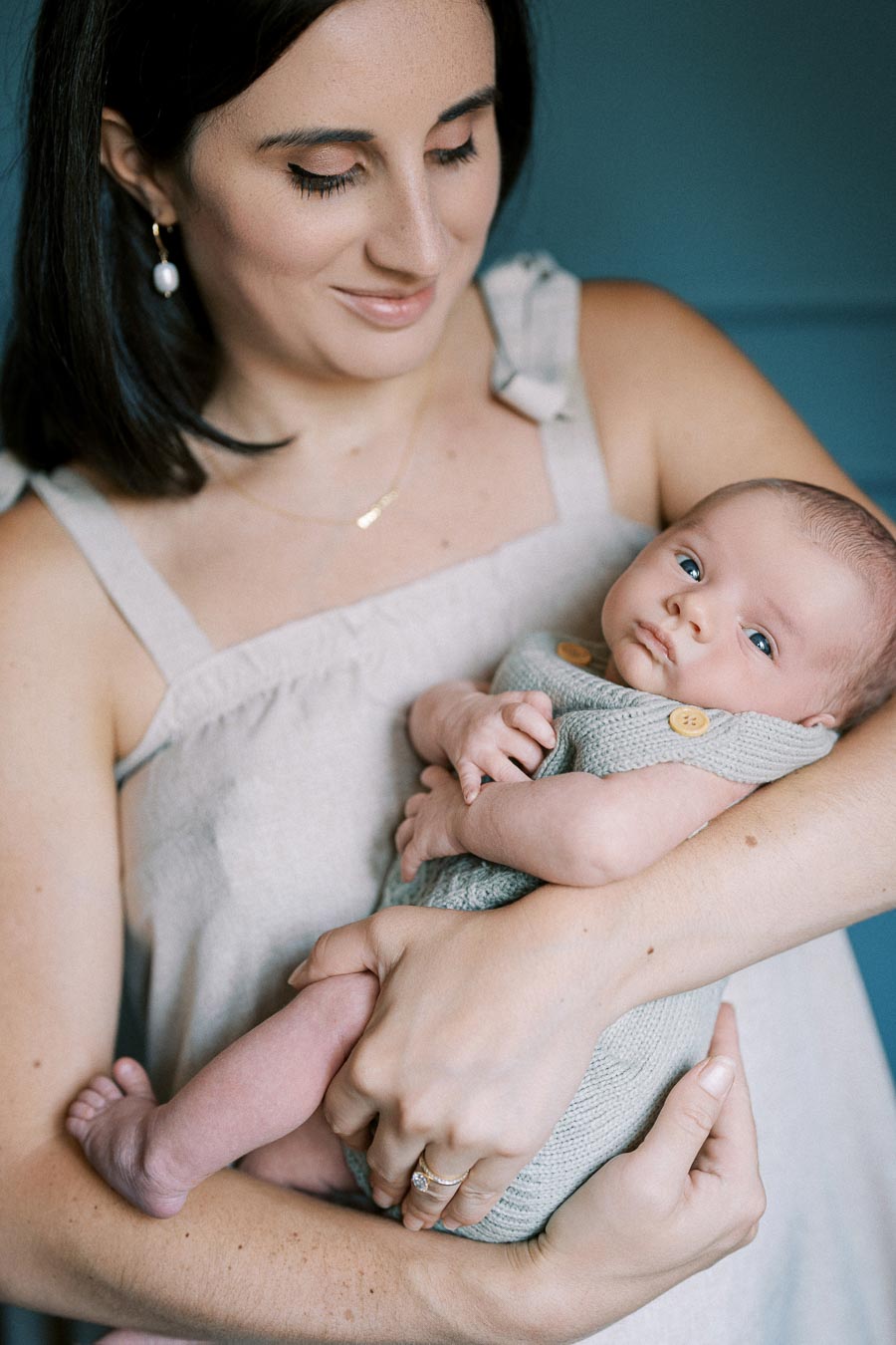 A mother lovingly cradles her newborn baby in her arms, showcasing a tender moment of maternal care and bonding.