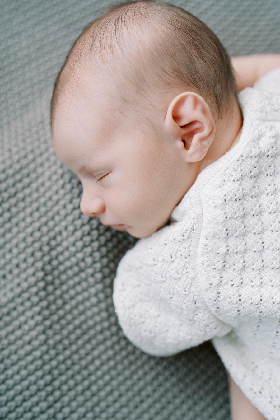 Close-up of a sleeping newborn baby during in-home lifestyle session by Toronto newborn photographer
