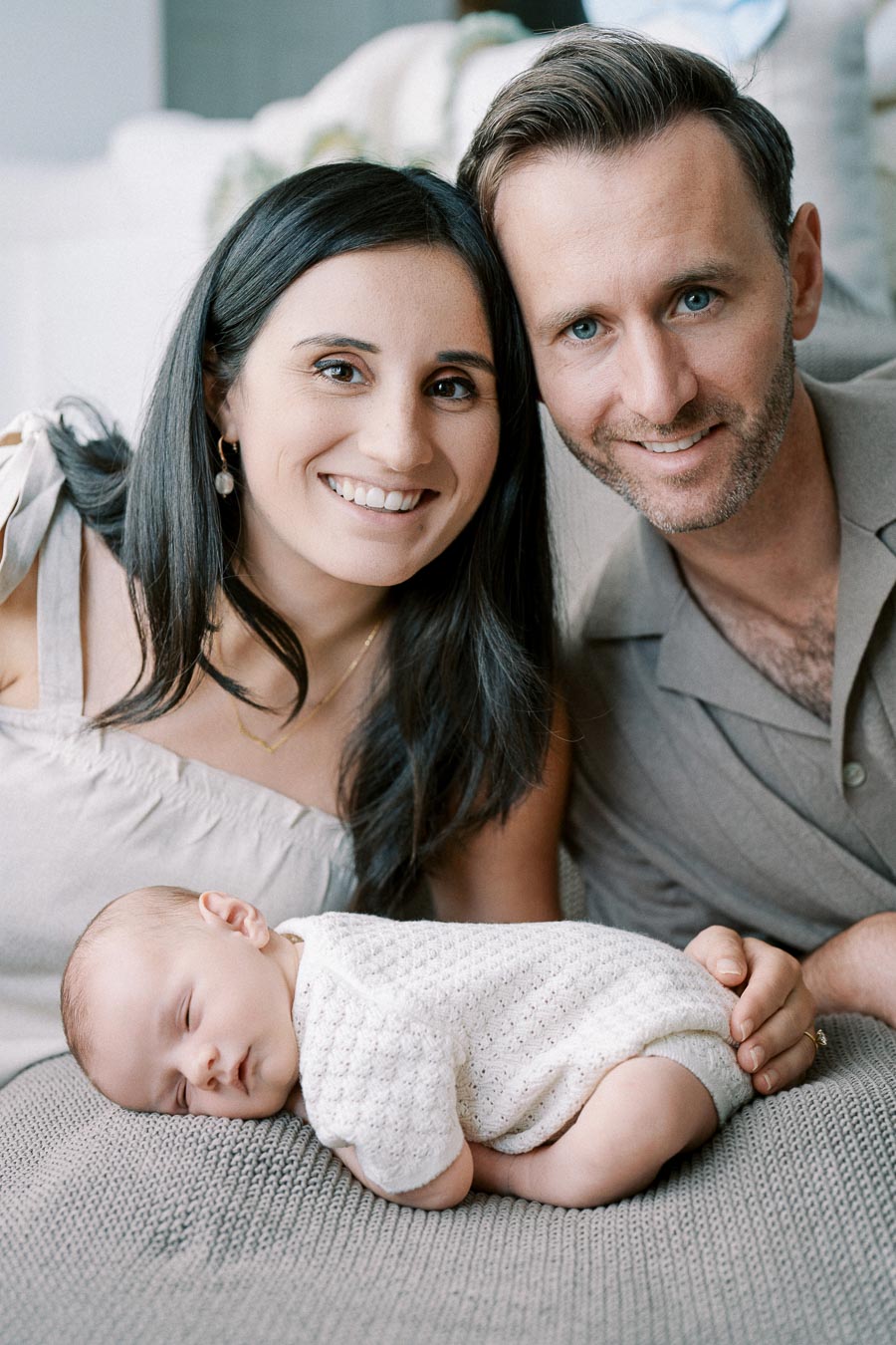 Parents smiling with their newborn baby during in-home Toronto lifestyle session