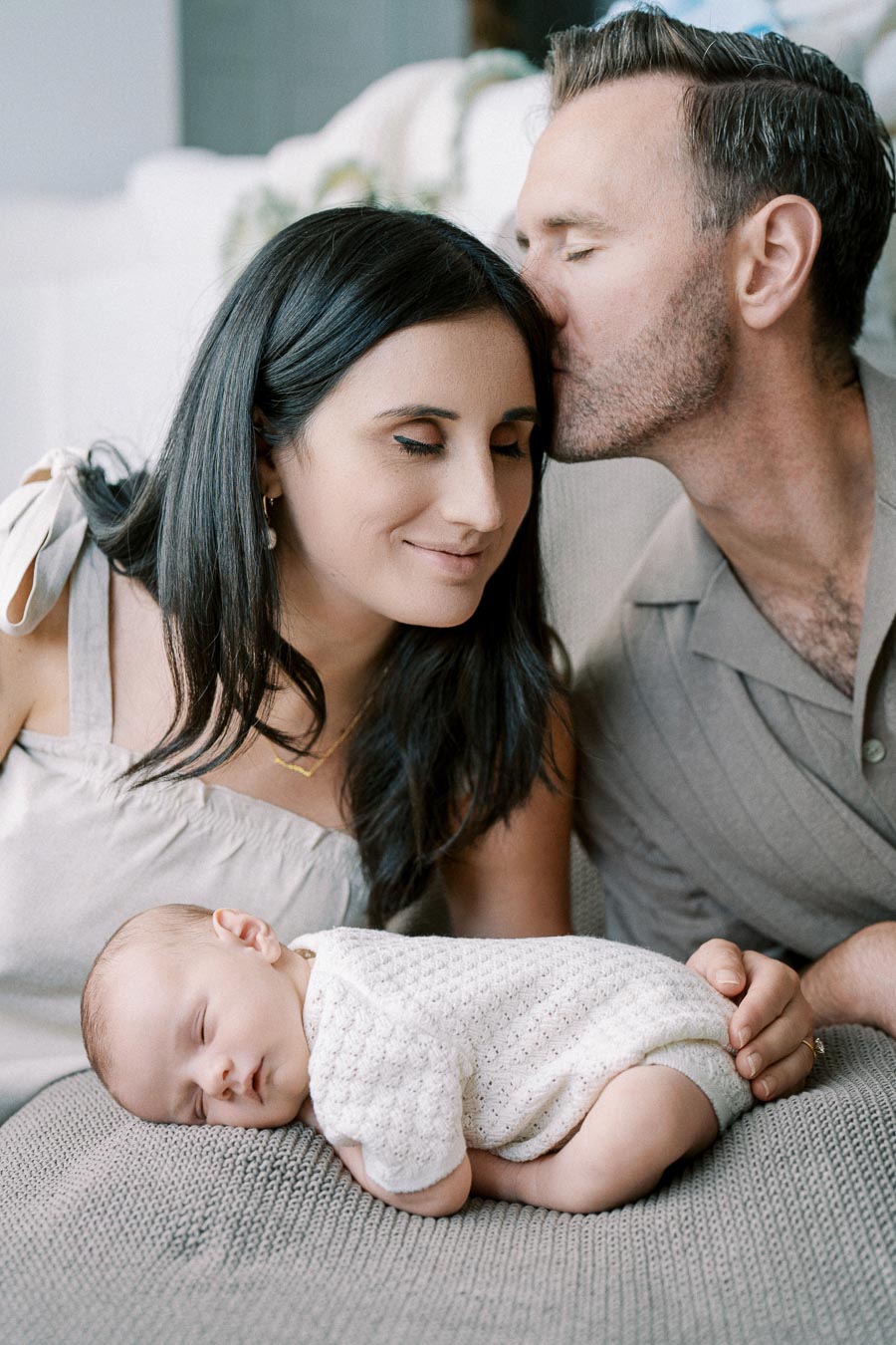 Parents with their newborn baby during an intimate in-home session by Toronto newborn photographer