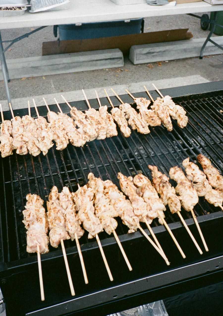 Grilled chicken skewers sizzling on an outdoor barbecue grill, showcasing a delicious summertime cookout scene.