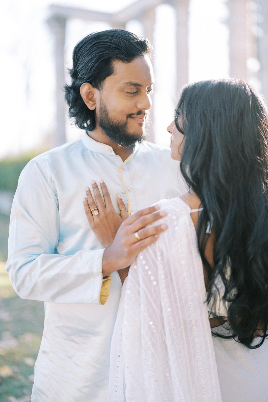 Couple Embracing in Sunlit Garden, Wearing Traditional Attire