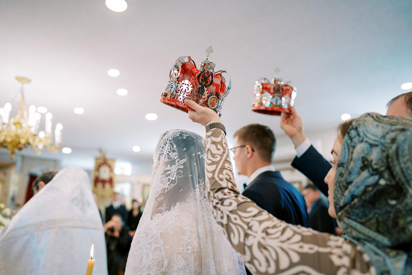 Orthodox wedding ceremony with bride and groom wearing crowns in church setting, highlighting traditional religious customs
