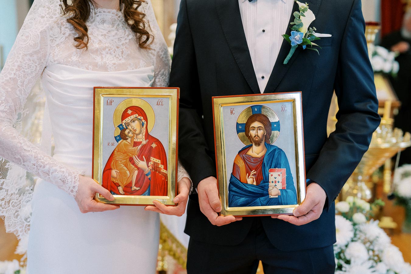 A bride and groom holding religious icons during a traditional wedding ceremony, showcasing cultural and spiritual elements associated with marriage rituals.
