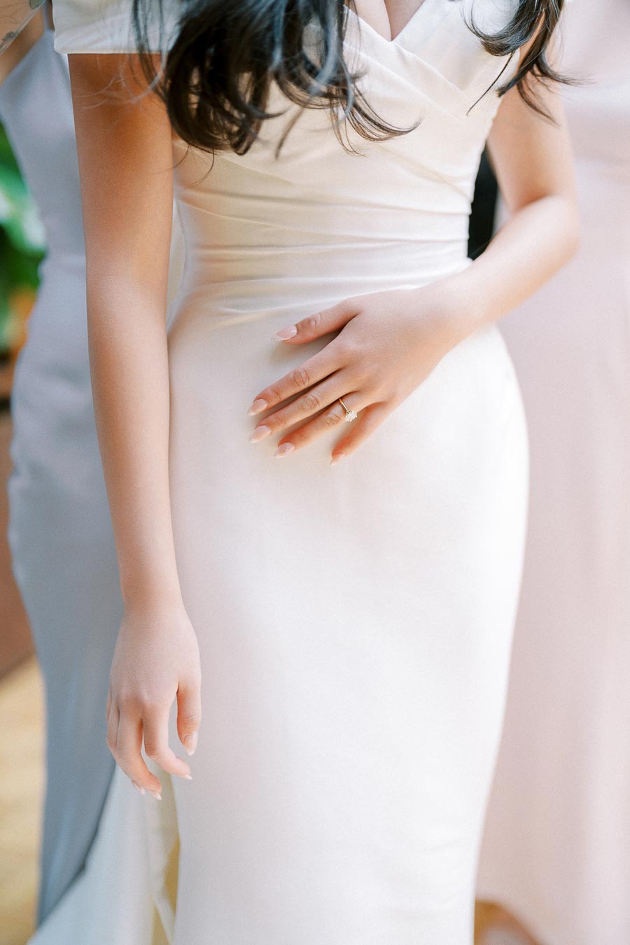 Bridal gown with elegant fit showcasing delicate ring and manicured hand.