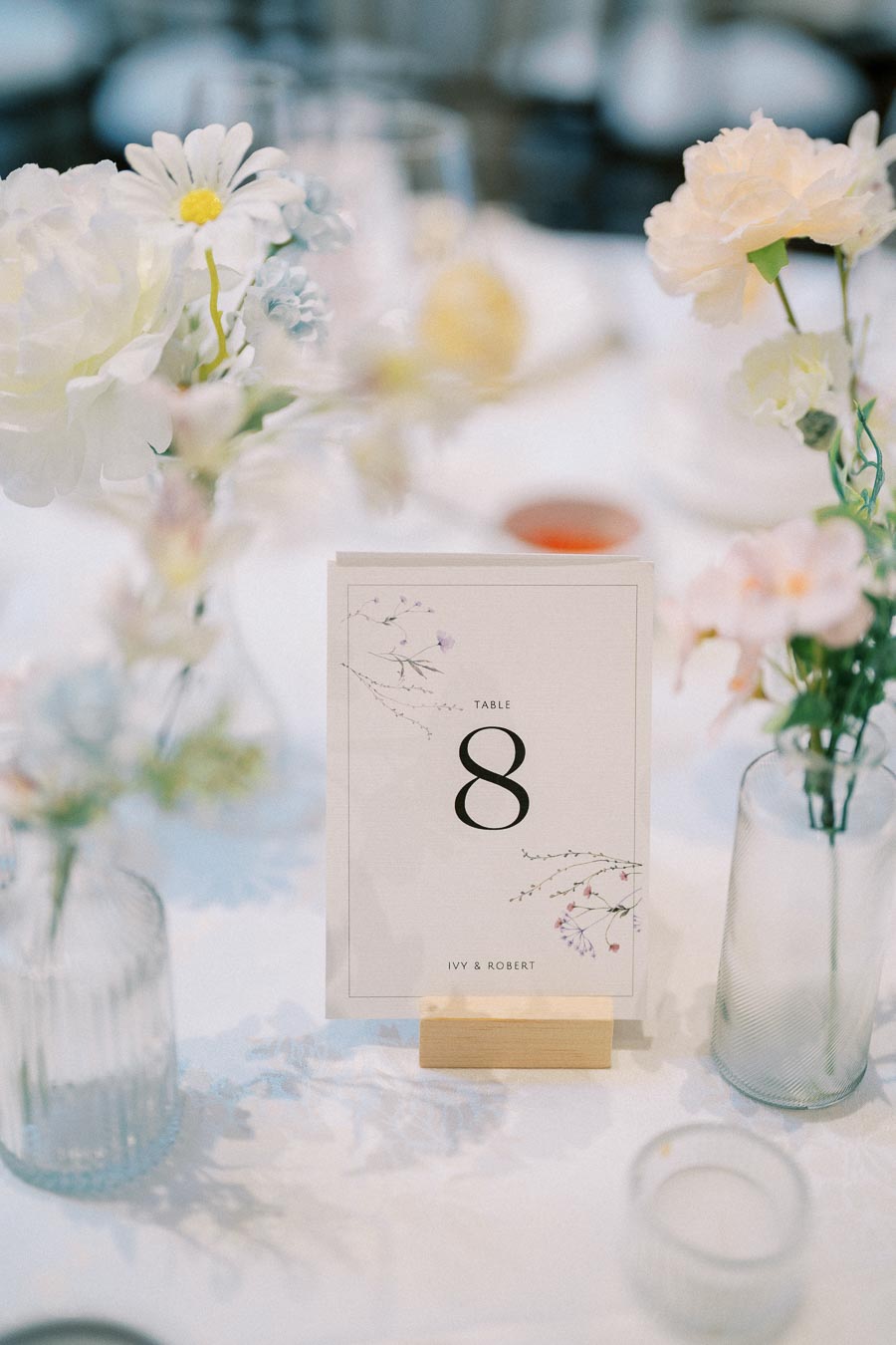 Wedding table setting with floral decorations and a card displaying Table 8.