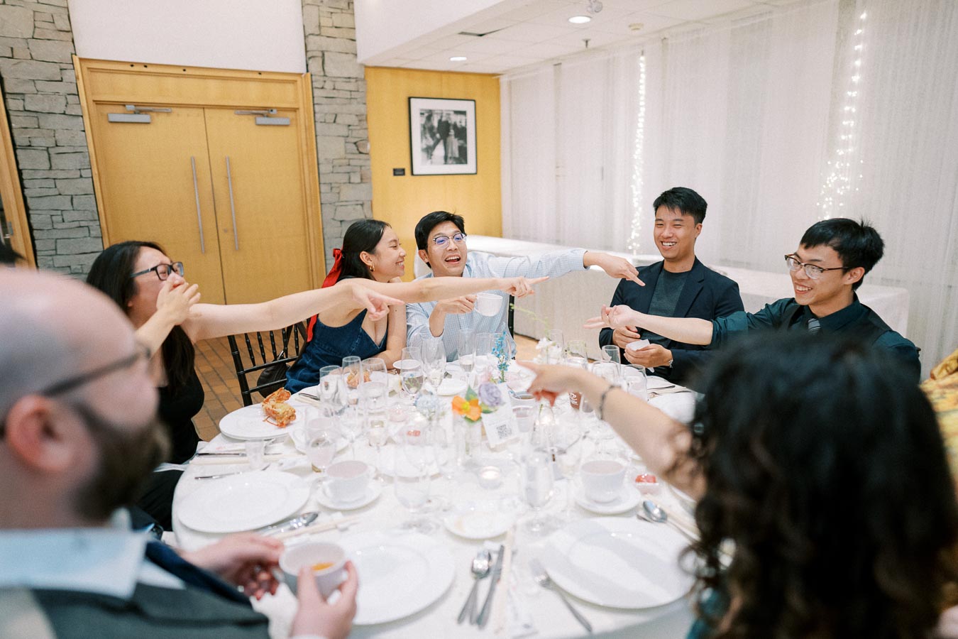 A lively group of friends enjoying a moment of laughter and camaraderie at a formal dinner event.