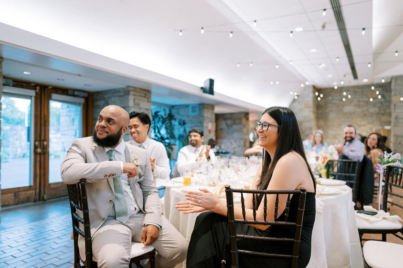 Guests enjoying a joyful moment at a wedding reception, surrounded by elegant decor and warm lighting.