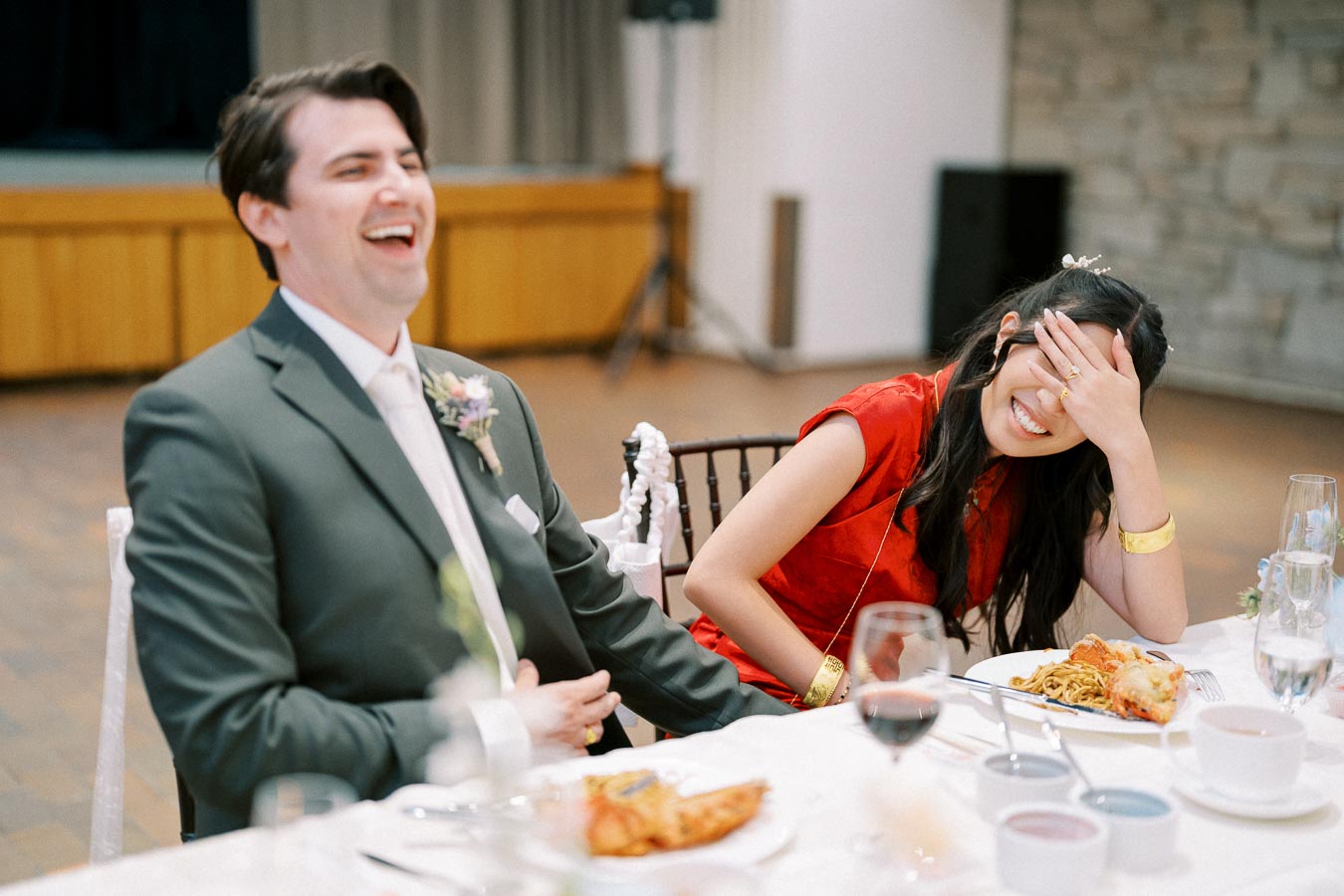 A joyful moment captured at a formal event, with a couple laughing together at a table.