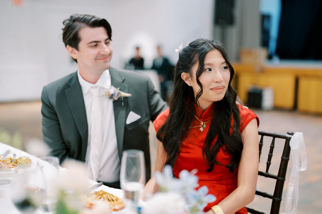 A couple enjoying a formal event, dressed elegantly with the woman in a red dress and the man in a suit.