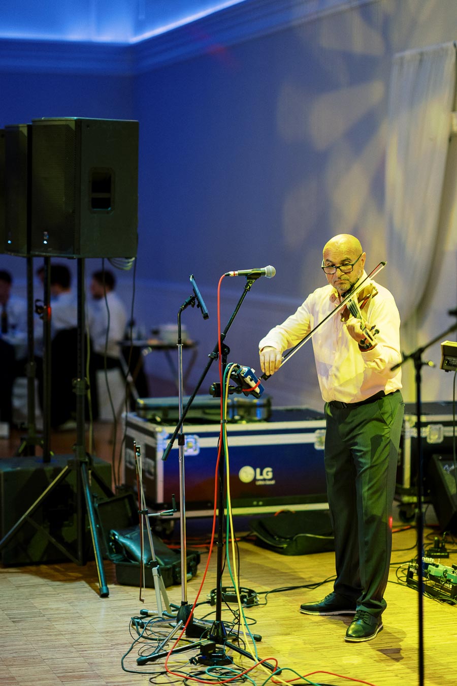 A man playing the violin on stage during a live music performance.