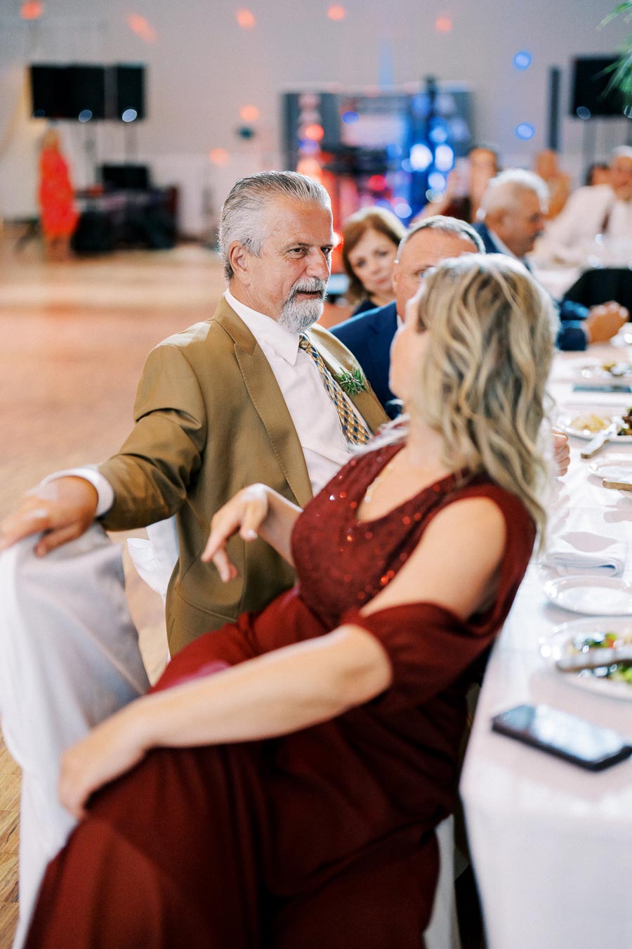 A man and woman dressed formally, sitting at a table during an event.