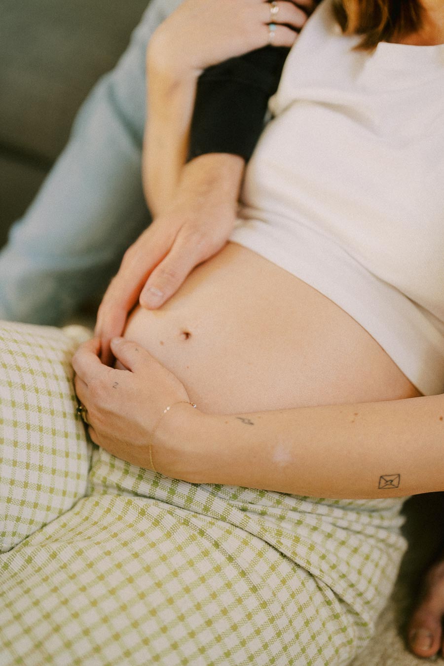 A close-up of a pregnant woman's belly, with hands gently resting on it, symbolizing care and anticipation.
