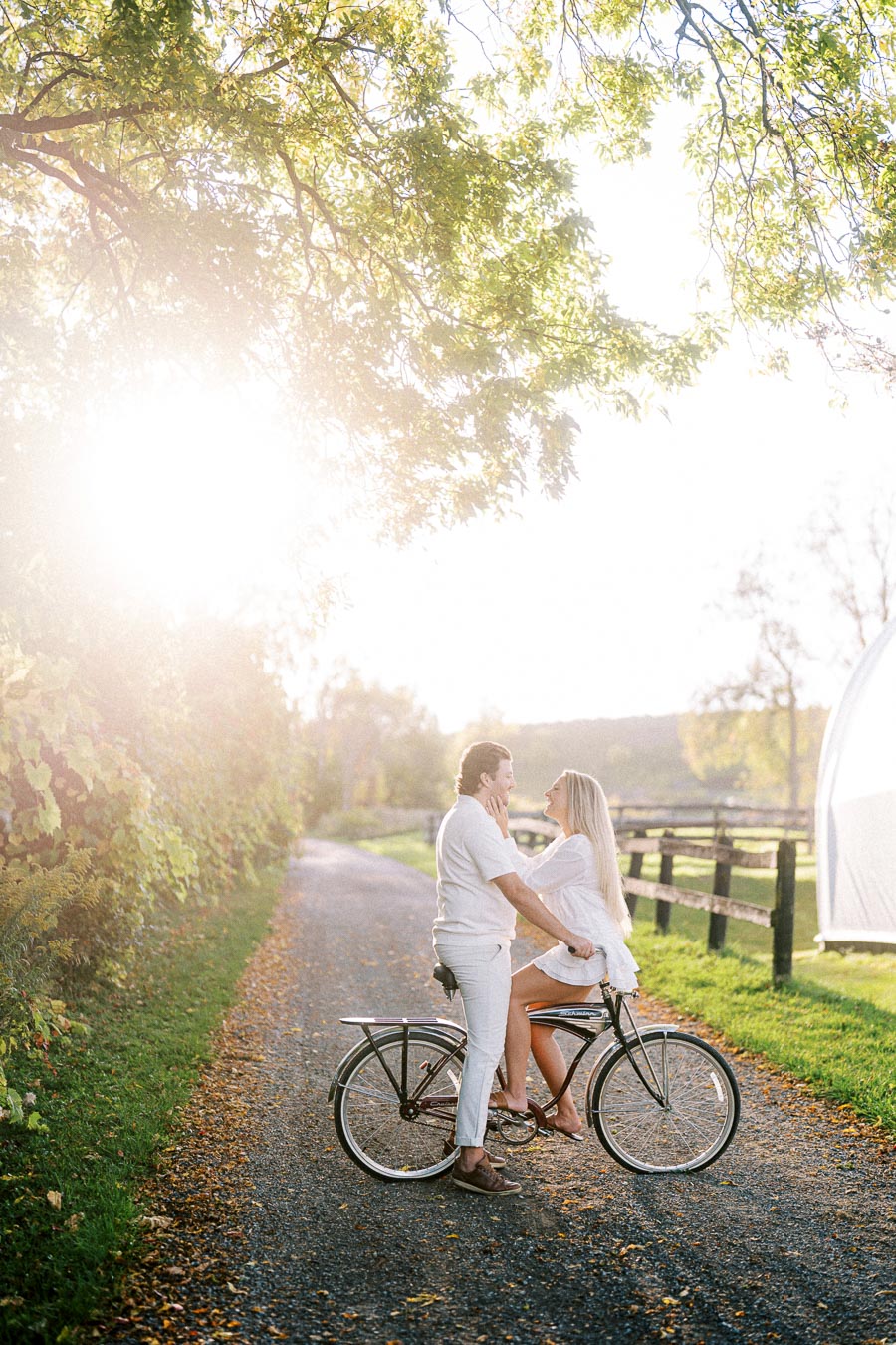 Romantic couple enjoying a sunny day on a bicycle path, surrounded by lush greenery.