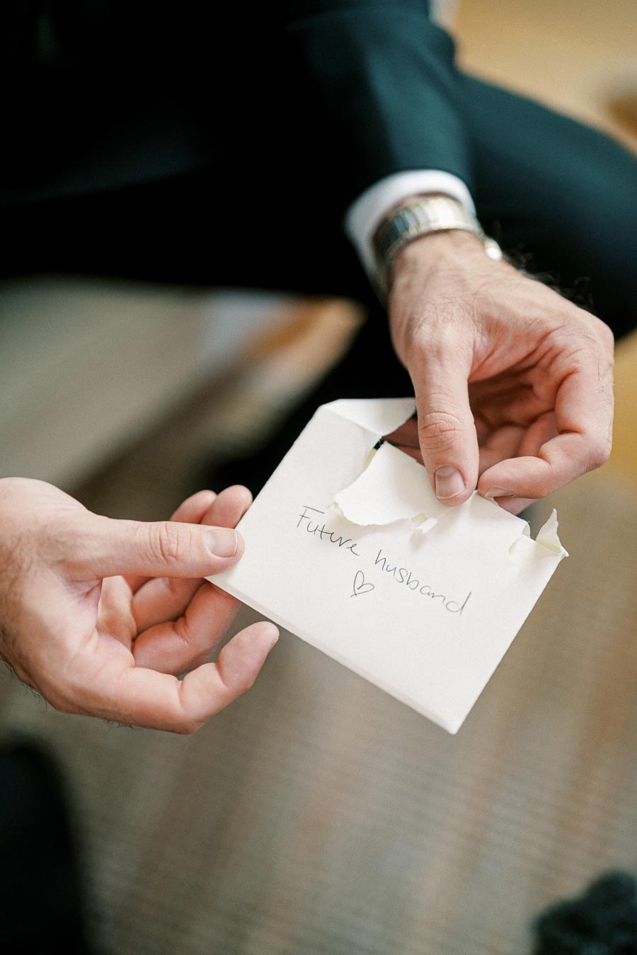 A close-up of a person's hands holding an envelope addressed to Future husband with a handwritten note, symbolizing a heartfelt message before a wedding or engagement.