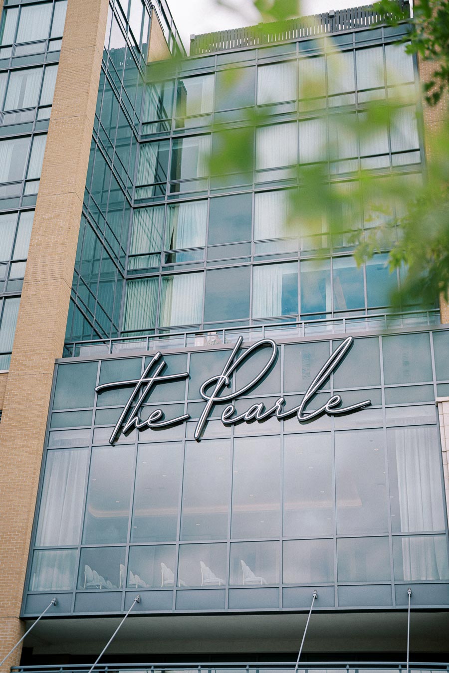 The Pearle hotel building facade with modern glass architecture and elegant signage.