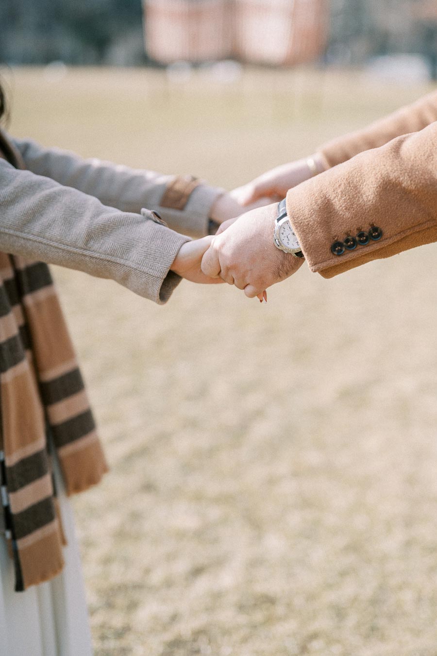 Two people holding hands outdoors, showcasing connection and togetherness in a sunny park setting.
