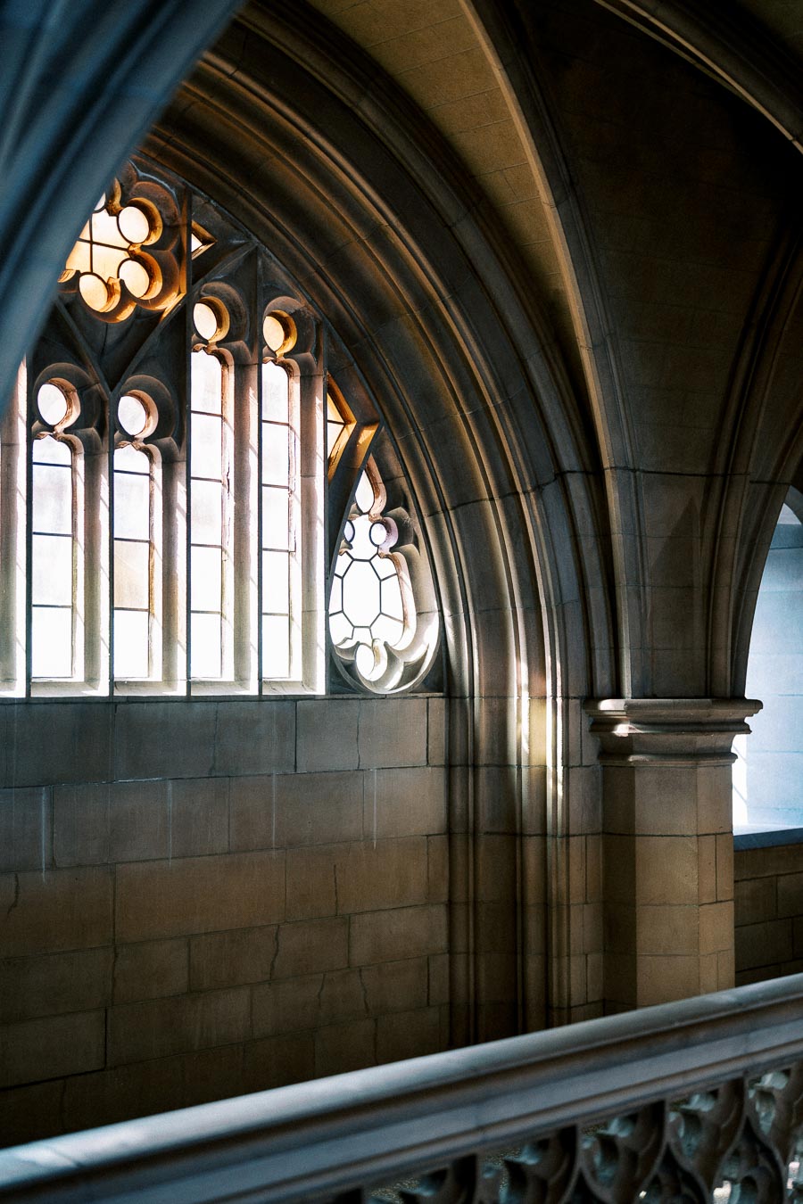 Historic Gothic architecture with intricate stained glass windows and arched stonework in a cathedral setting, showcasing