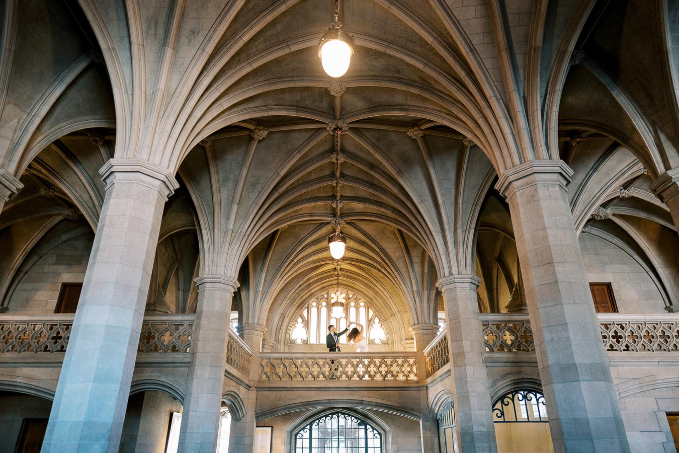 A stunning example of Gothic architecture featuring a vaulted ceiling with intricate stone columns and arches, illuminated